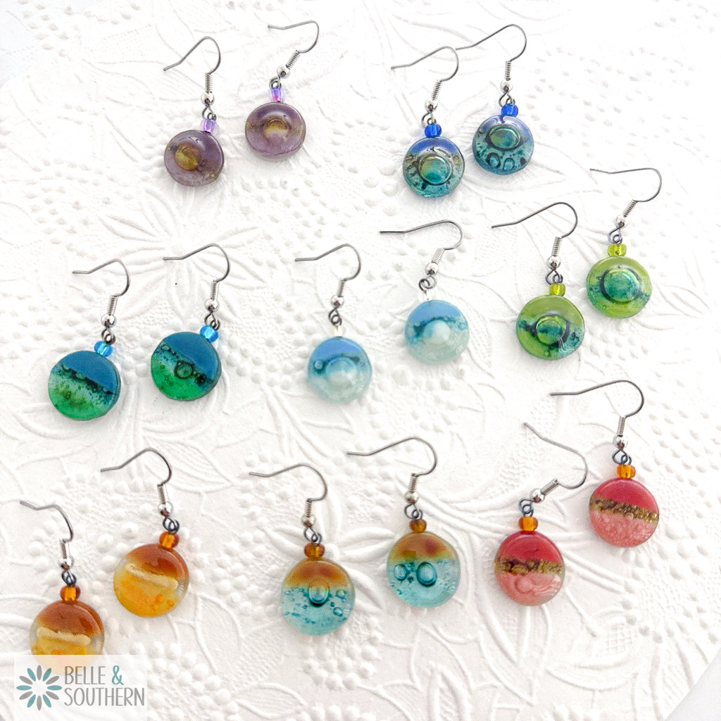 Colorful earrings on a textured white background with 'Belle & Southern' branding.