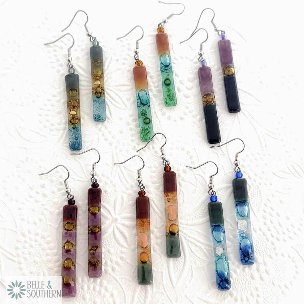 Fusion Glass Dangle Earring Variety on textured white surface.