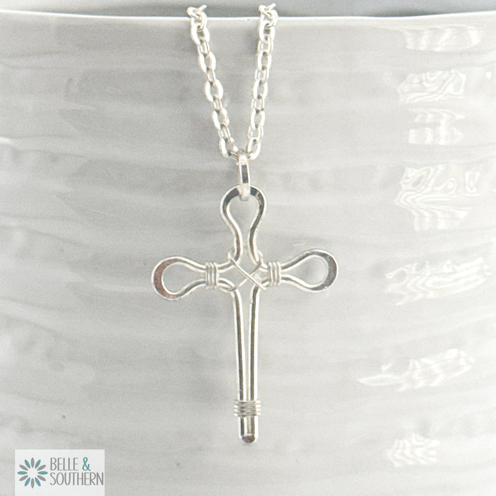Silver cross necklace on a white background with 'Belle & Southern' branding.