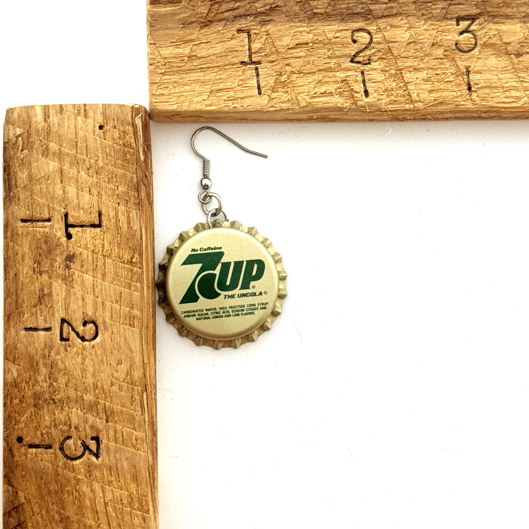 Gold with Green 7 Up on Stainless Steel Ear Wires next to ruler