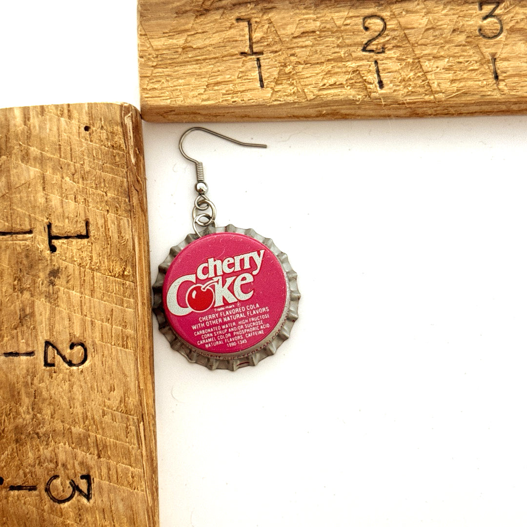 Pink Cherry Coke Bottle Cap on Stainless Steel Ear Wire next to ruler