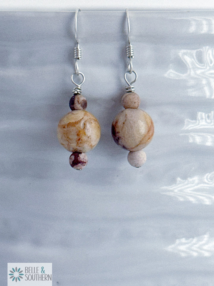 Pair of Zebra Jasper Stone bead earrings on a white vase with 'Belle & Southern' branding.