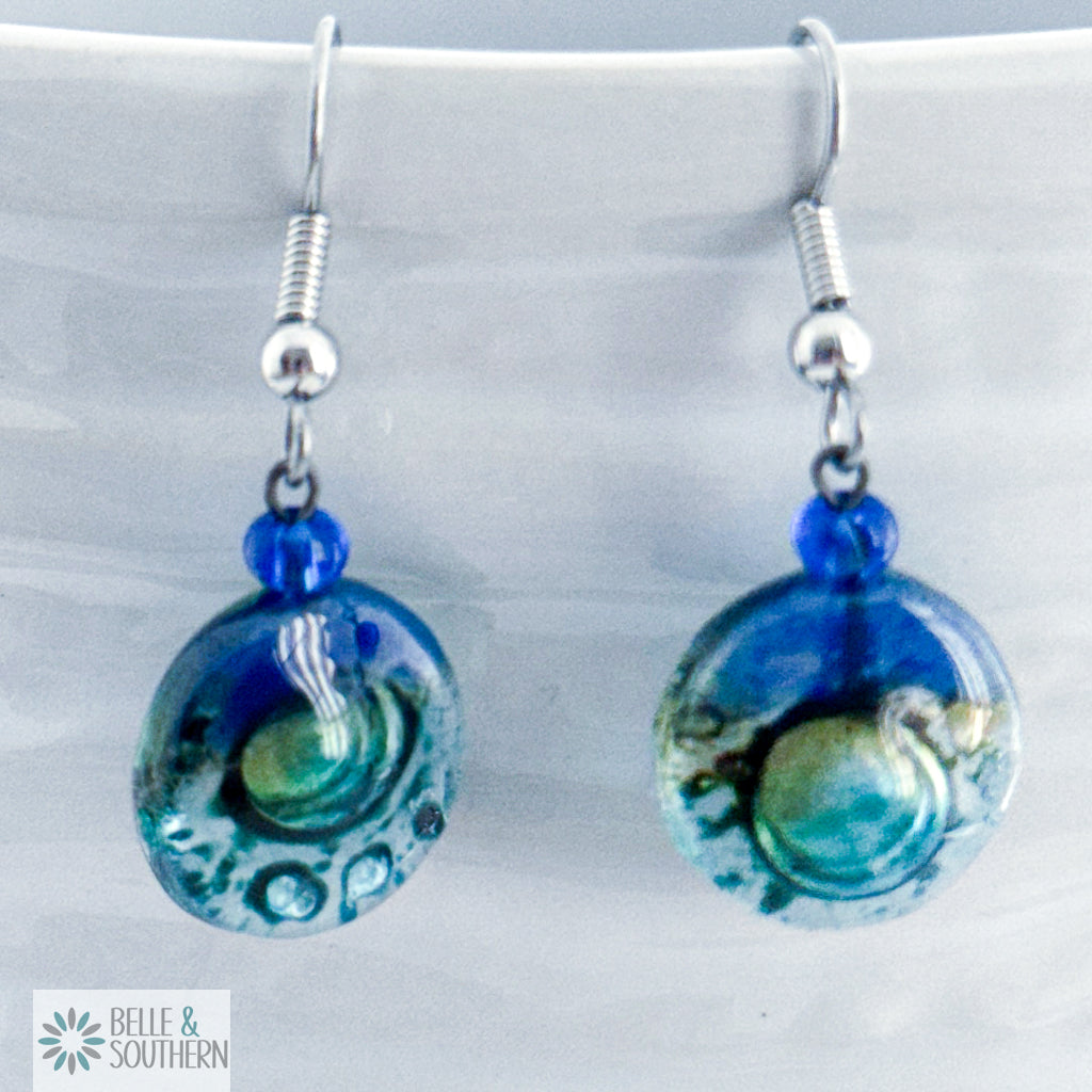 Pair of Blue, Gold, and Light Blue Fused Circle Glass Earrings on white vase featuring Belle and Southern Brand