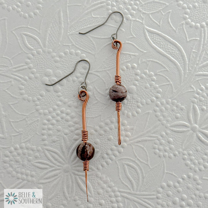 Gem on a Stem Zebra Jasper earrings on a white embossed background
