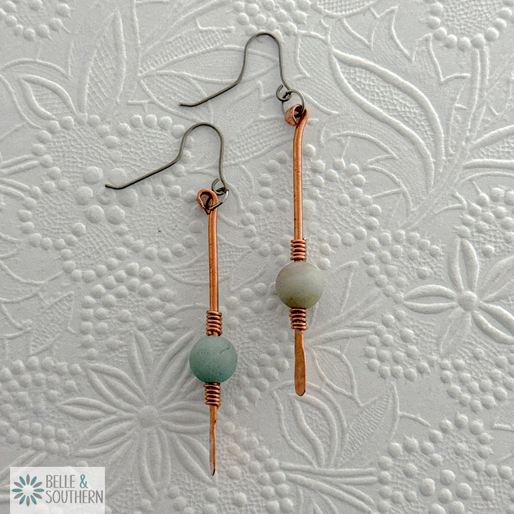 Gem on a Stem Amazonite on copper dangle earrings on an embossed white background