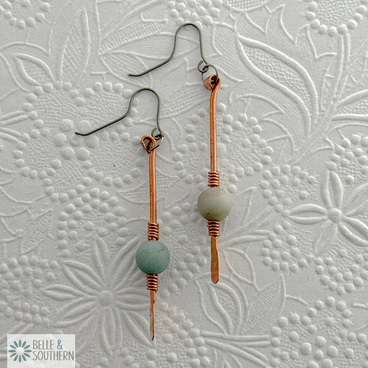 Gem on a Stem Amazonite on copper dangle earrings on an embossed white background
