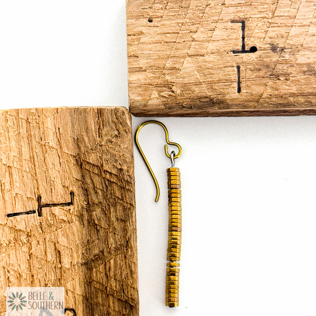 Gold stacked hematite earring next to wooden ruler on white background featuring 'Belle and Southern' brand
