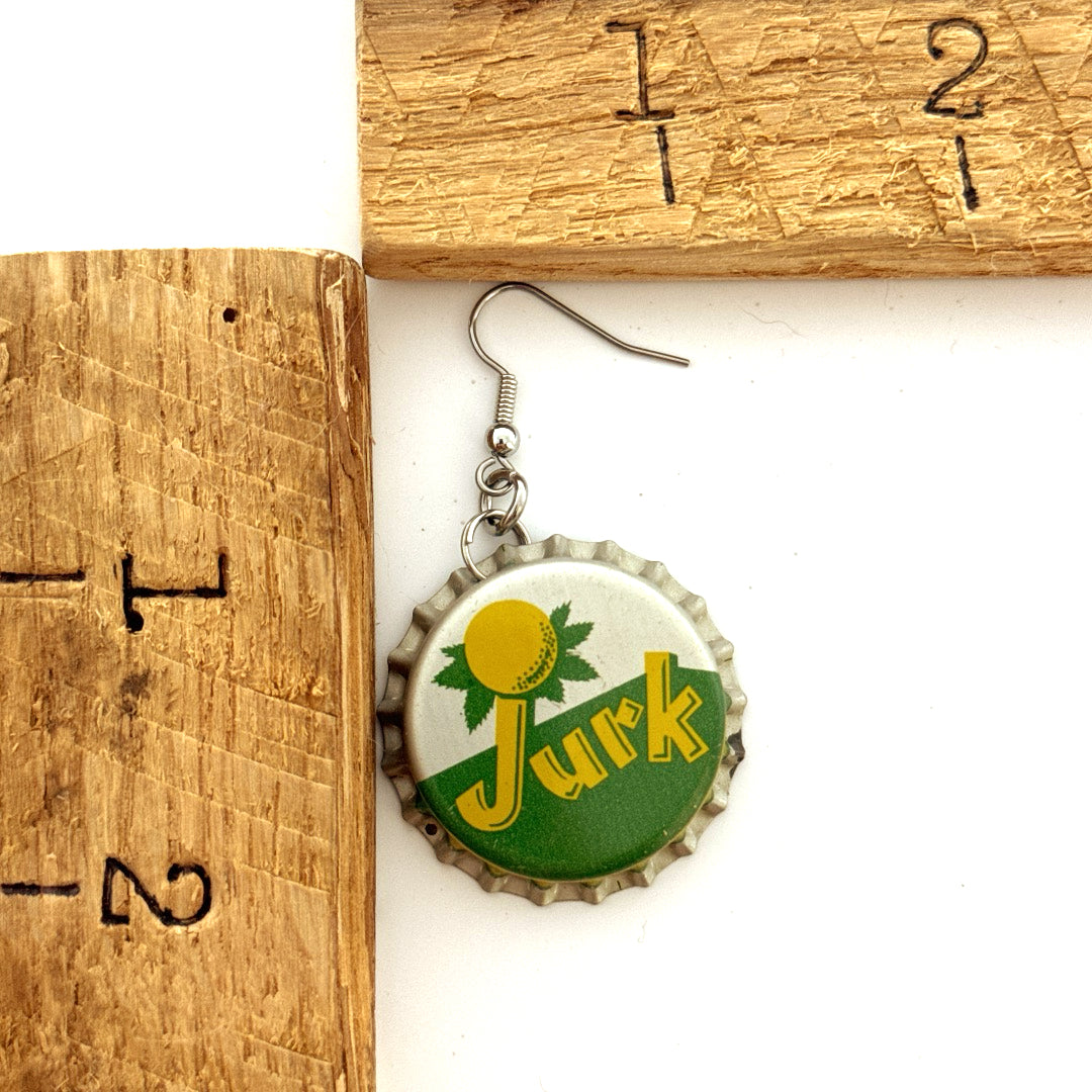 Green, Silver, Yellow Jurk Bottle Cap on Stainless Steel Ear Wires next to ruler