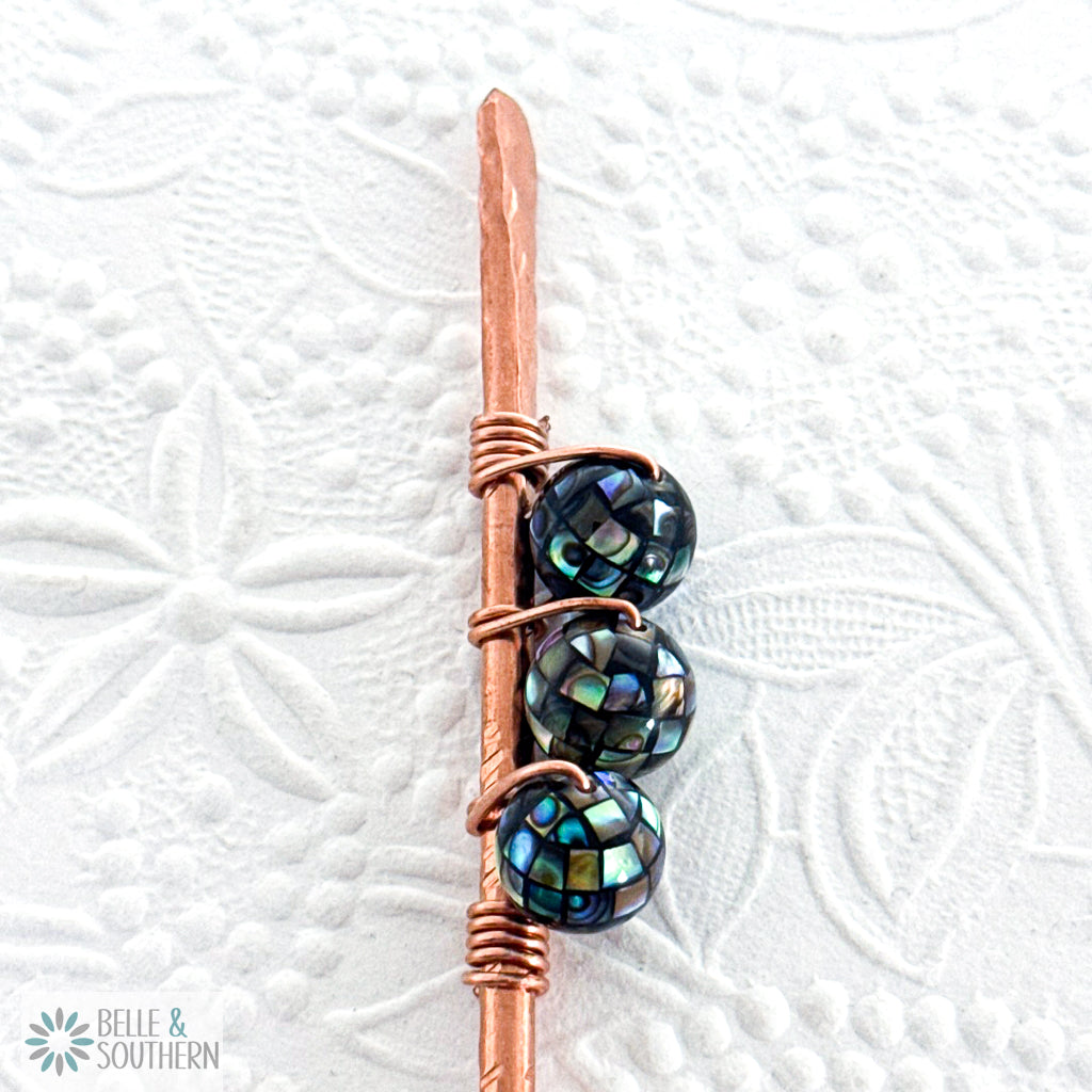 Upclose view of 3 Mosaic Abalone Shell Beads on textured copper hair stick