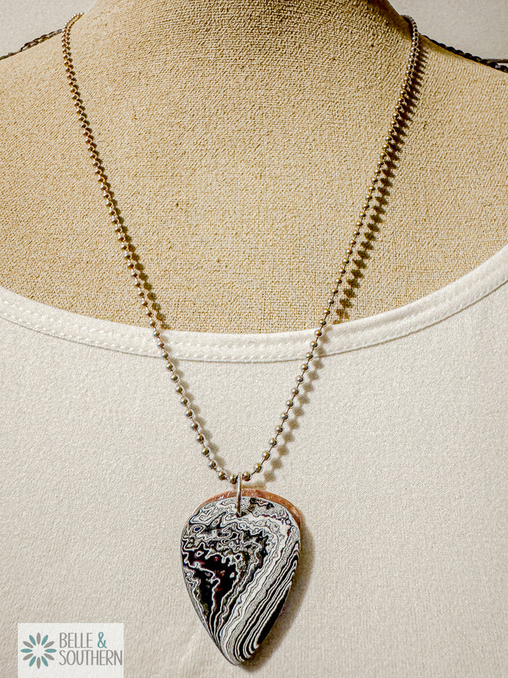 Center Lane Pulse Fordite Guitar Pick necklace  in black and white enamel layers on stainless steel bead chain.
