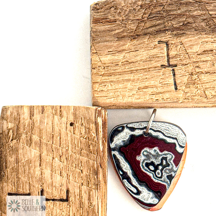 Fordite Guitar Pick Shape Pendant next to a ruler