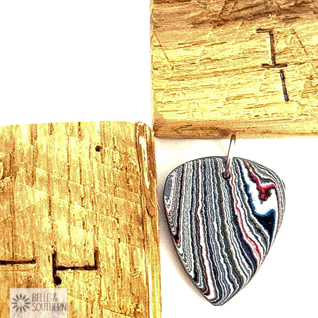 Fordite Guitar pick pendant next to a ruler , featuring the brand 'Belle & Southern'.