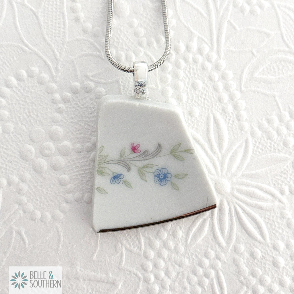 Quiet Bloom Fragment Necklace on white floral pattern background
