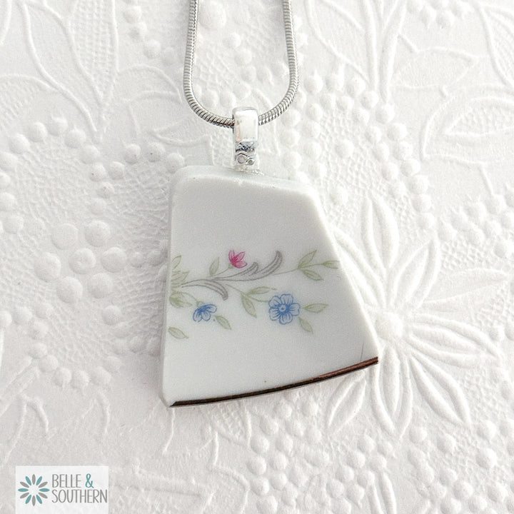 Quiet Bloom Fragment Necklace on white floral pattern background
