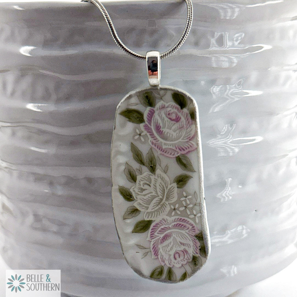 Handcrafted porcelain fragment necklace featuring cascading pink and sage roses on ivory.