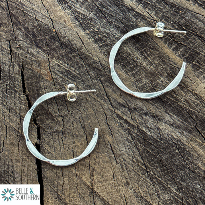 Sterling Silver Hammered Texture Hoop Earrings resing on a piece of wood