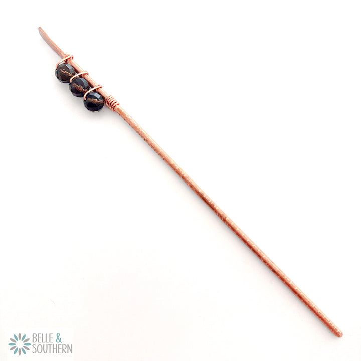 Smoky Quartz Gemstone Beads wrapped on a textured copper hair stick sitting on white background
