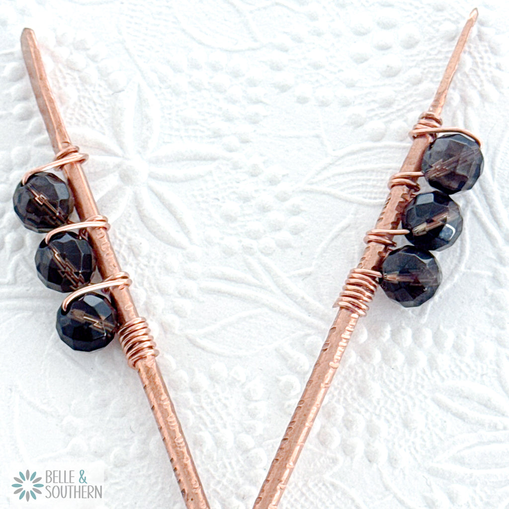Show: Pair of handcrafted smoky quartz copper hair sticks with faceted gemstone beads, displayed on a floral textured background for reference only. Single Hair Stick Listing