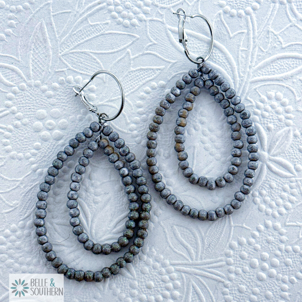 Pair of silver/gray beaded teardrop earrings on a textured white background with 'Belle & Southern' branding.