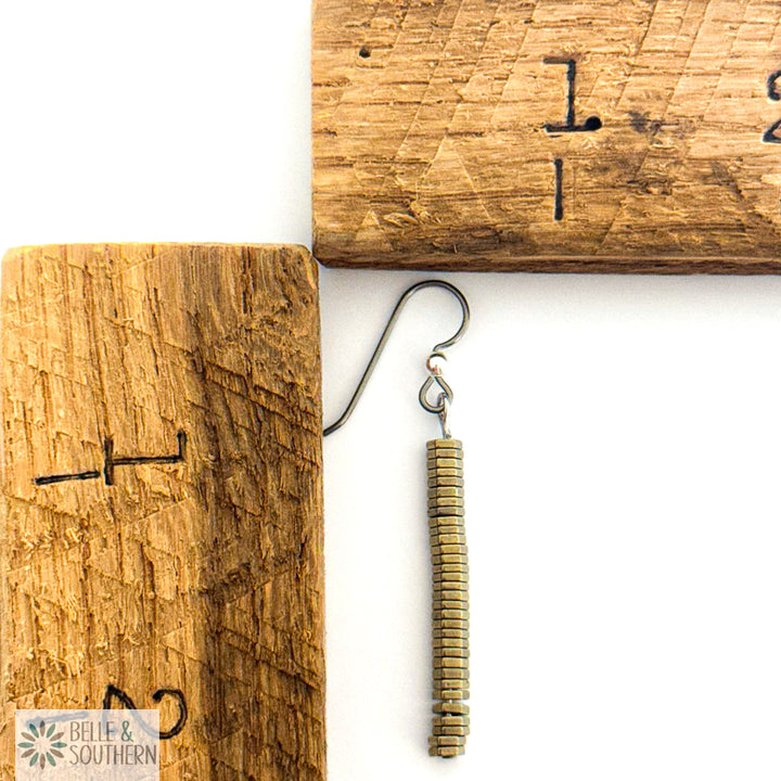 Titanium stacked hematite earring next to wooden ruler on white background featuring 'Belle and Southern' brand