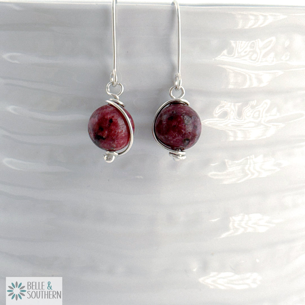 Pair of earrings with Aggie Maroon Jade gemstone beads on a white background, branded 'Belle & Southern'.