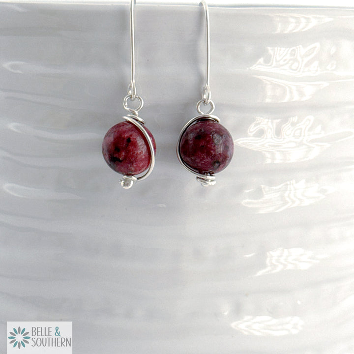 Pair of earrings with Aggie Maroon Jade gemstone beads on a white background, branded 'Belle & Southern'.
