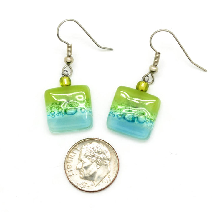 Green and blue square glass earrings with a dime for scale on a white background